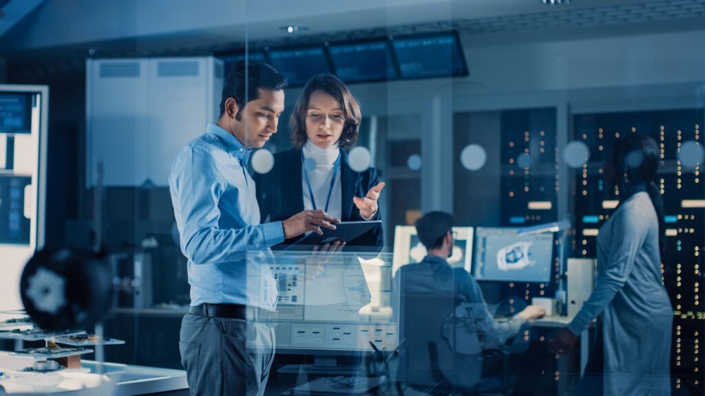Two professionals reviewing workforce planning data and discussing clean tech skills and capability development within an organisation, highlighting the coordination required across functions to deliver the energy transition.